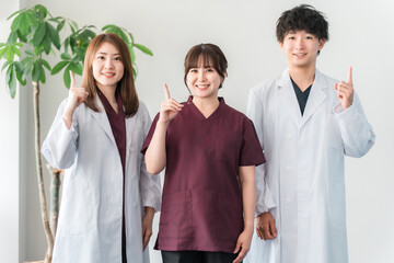 Male and female medical staff including doctors, nurses, and doctors wearing white coats and scrubs