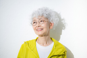 スポーツウェアの見上げるグレイヘアの元気なシニア女性クローズアップ