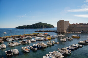 Traditional boats anchored near the historic stone walls of Dubrovnik Old Town, scenic Mediterranean coastline and ancient fortress in Croatia, sunny day © Yar