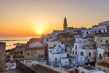 Fototapeta premium Golden hour magic over a historic whitewashed village cascading to the mediterranean sea