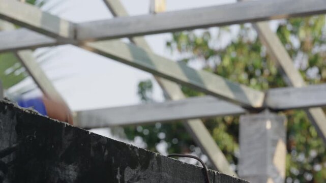 Construction worker pouring fresh concrete into formwork at building site. Structural engineering process and foundation work in outdoor construction project.