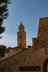 Obraz premium Vertical view of Dubrovnik old town harbor with boats and Dominican Monastery bell tower, Croatia 