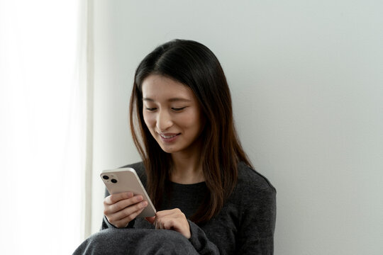 スマートフォンを見る若い日本人女性