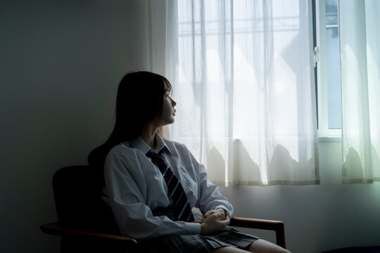 窓の外を眺める日本人女子高生