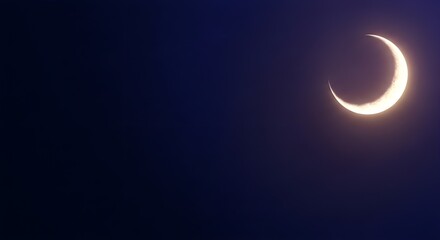 Crescent moon illuminated against a dark blue sky symbolizing night