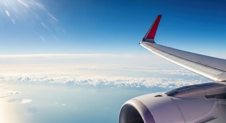 Airplane wing flying above the clouds on a sunny day.