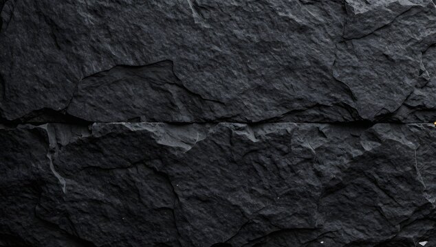 Cracked and layered black rock formation presents a rugged natural texture