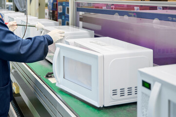 Engineer conducts microwave leakage testing on production line for quality assurance