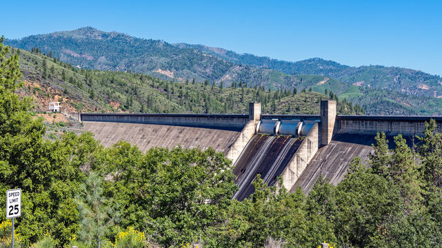 Panorama of the Shasta Dam floodgates with a speed limit sign in the foreground near Redding, California, USA