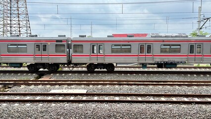 Fototapeta premium Modern Commuter Train on Tracks Under a Cloudy Sky