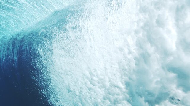 Bright underwater wave face glowing with sunlit texture and clear tropical water tones