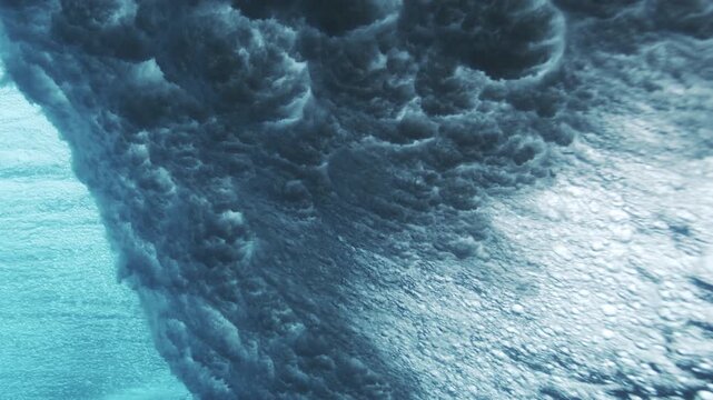 Breaking underwater wave surface with shimmering highlights and textured blue motion