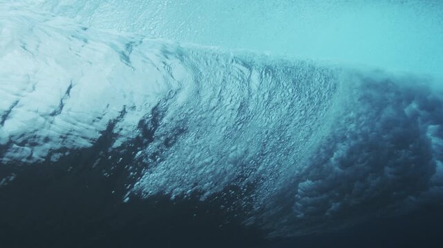 Underwaterbehind a powerful tropical wave with shimmering light and rolling water texture