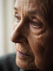 Fototapeta premium Close-up portrait of a thoughtful elderly woman with expressive eyes, showcasing the wisdom and character of age