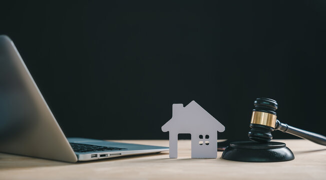 Foreclosure house concept depicting house model, gavel and laptop indicates real estate law, bankruptcy, property auction, home mortgage, legal sale, court, debt issues