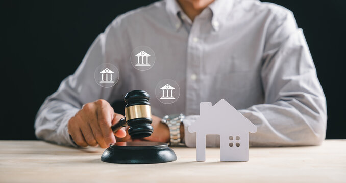 House foreclosure property law concept, person holding gavel on block, small home model, real estate auction sale, mortgage debt, legal court proceedings, bankruptcy division