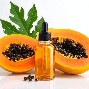 A bottle of oil with halved papayas and seeds