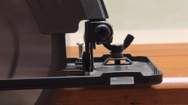 A heavy-duty circular saw blade spins rapidly to slice through a wooden surface. This intense cutting action results in a loud, roaring whine