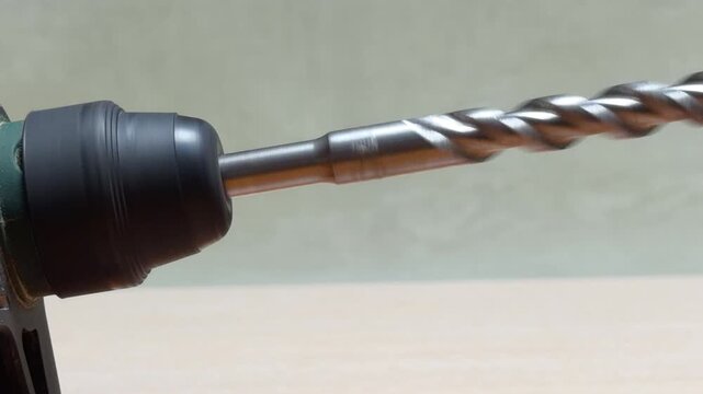 A powerful hammer drill rotates a masonry bit at low speed. This deliberate action creates a heavy rhythmic thump and a gritty mechanical growl as the internal hammer mechanism engages.