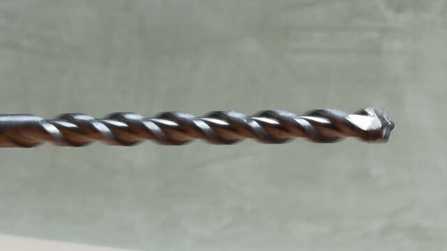 A powerful hammer drill rotates a masonry bit at low speed. This deliberate action creates a heavy rhythmic thump and a gritty mechanical growl as the internal mechanism engages.