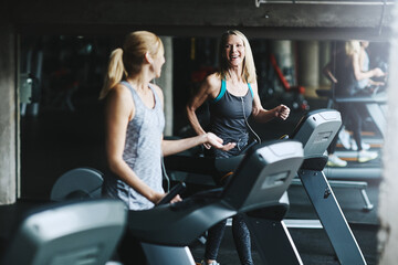 Runner, friends and fitness with women on treadmill for speed challenge, workout and training. Gym...