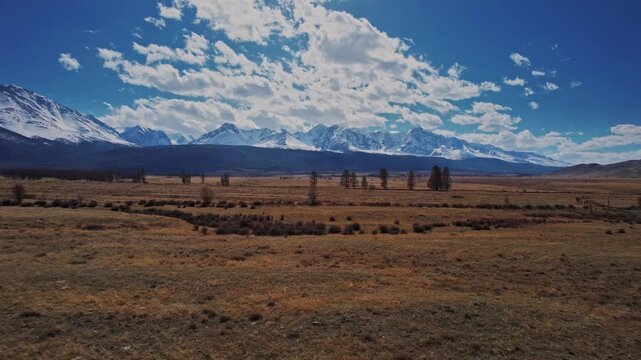 Beautiful landscape road in autumn forest with snow peaks mountains Chuysky tract, Altai Kurai steppe Russia. Aerial top view.