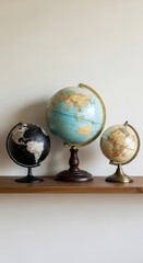 Trio of vintage globes on wooden shelf displaying world map with intricate details in elegant home decor setting