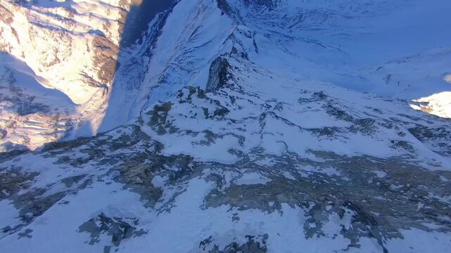 High speed FPV drone dive down steep snowy mountain fce