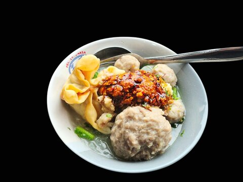 Indonesian Meatball Soup Bakso with Chili Sauce Isolated on Black