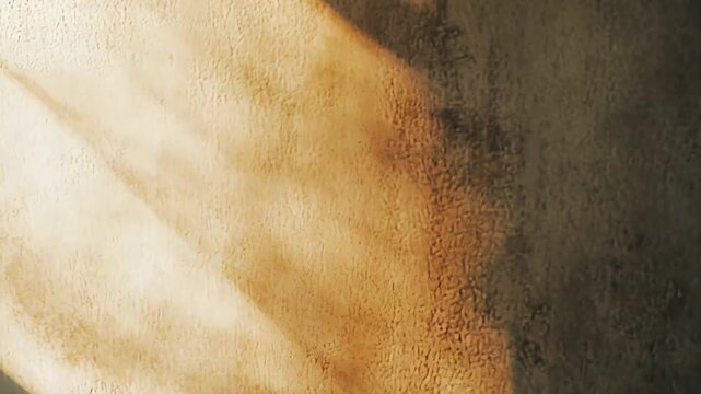 Sunlight casting strong, geometric shadows across a textured concrete wall, highlighting patterns and contrasts as warm ambient light fades into darkness
