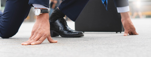 Businessman set in start running position prepare to fight in business race.