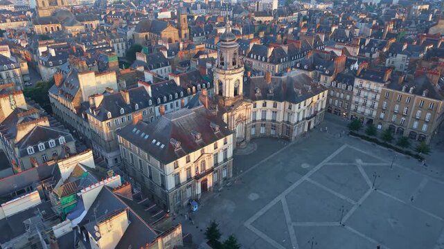 Place de la Mairie, the city hall, and the opera house at sunrise in the historic center of Rennes, France. Aerial backward ascending