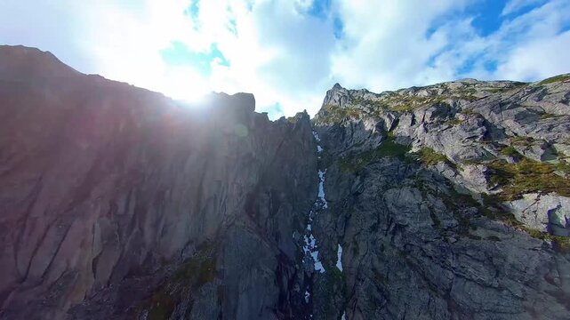 Aerial FPV Drone Flight Through Steep Rocky Gorge andNarrow Couloir with Green oss Details