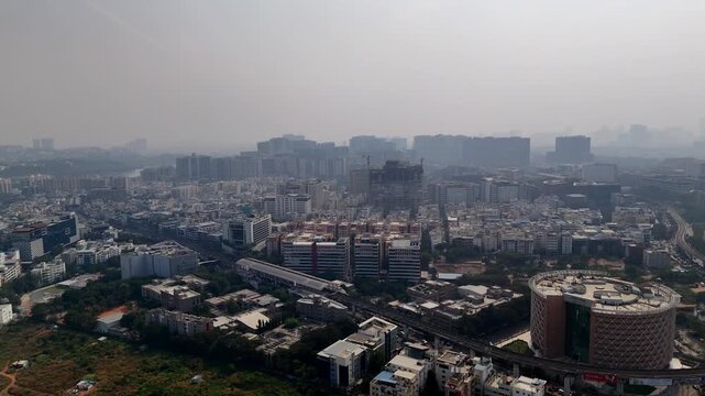 Aerial footage of a developed city in India in fog. Hyderabad is the City of Destiny for IT and Pharmaceutical companies skyscrapers of India. Dense urban setting transitioning to modern city center.