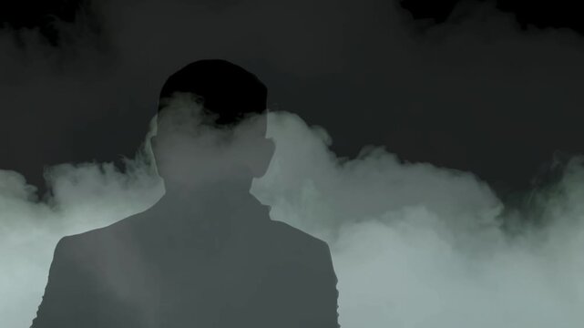 Young man in the dark. Man silhouette on white smoke