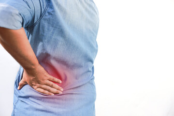 Middle aged Asian man suffering from chronic back pain or office syndrome while sitting. Red inflamed area on lower back, kidney problem, spinal injury, and orthopedic healthcare concept.