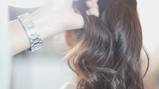 Master woman hairdresser dries the girl's hair with a hairdryer after washing in a beauty salon.