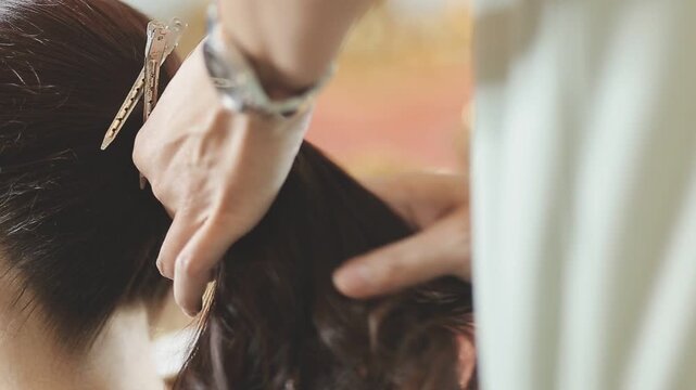 Master woman hairdresser dries the girl's hair with a hairdryer after washing in a beauty salon.