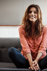 Obraz premium Woman, portrait and laughing on couch, home and chilling on weekend, peace or stress free on holiday. Happy, person and rest on break in lounge, comfortable and wellness on sofa and confident in USA