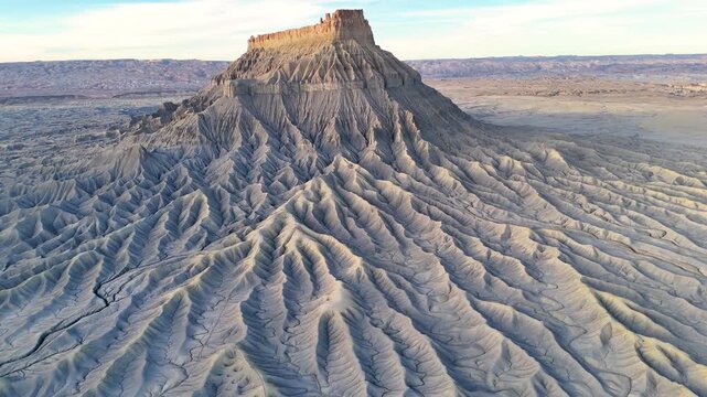 Factory Butte is an iconic 457-meter-tall monolith located 19 kilometers west of the town of Hanksville, Utah, along Highway 24. With its ridges and undulating surface, its unique, desolate landscape 