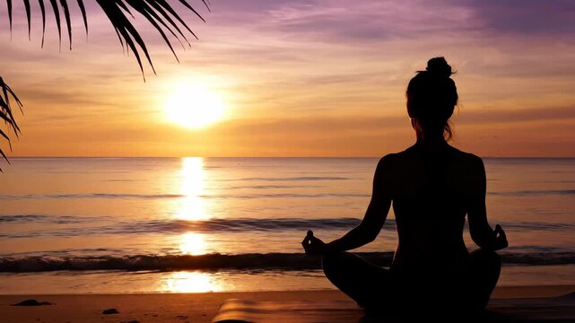 Silhouette of a Woman Meditating on a Beach at Sunset.
