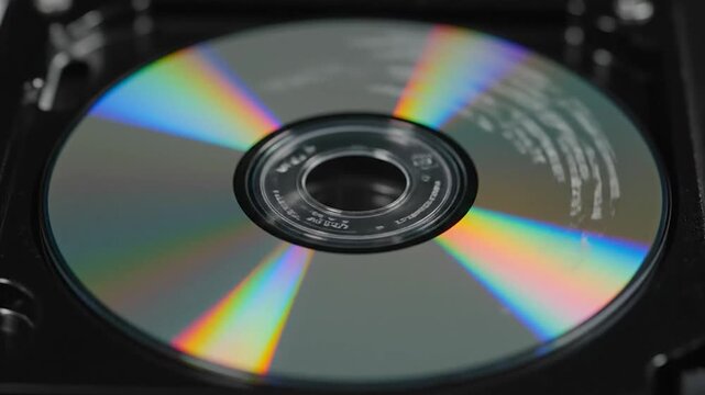 A close-up view of a shiny compact disc spinning in a player