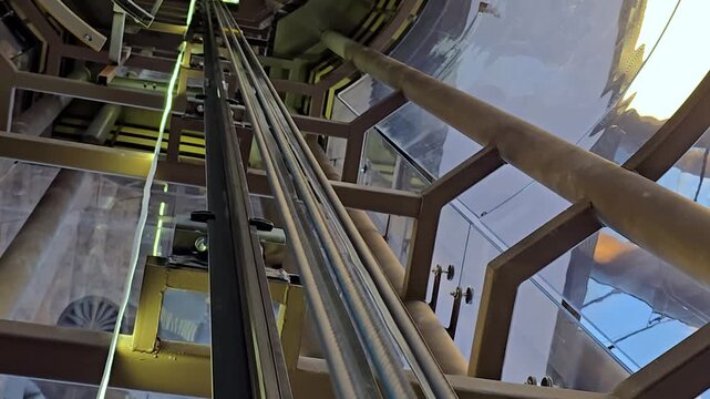 The elevator shaft: A view of the descent into the elevator An industrial elevator system in action. The elevator car moves upwards, suspended . High quality 4k footage
