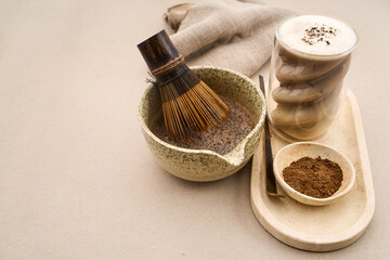 Preparing cacao latte with bamboo whisk and powder