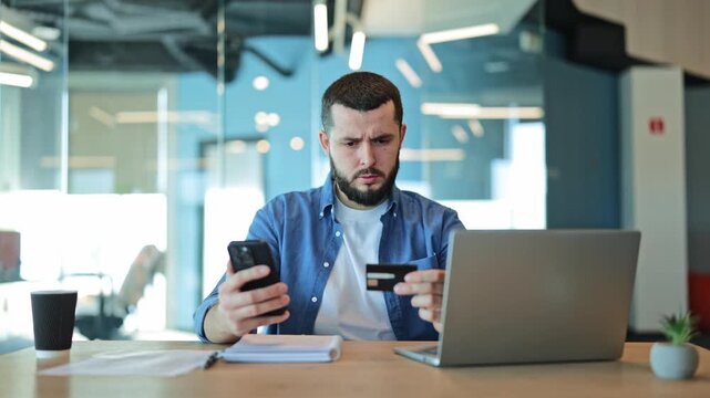 Anxious business man experiences financial concern disappointment during failed online payment using credit card and smartphone. Reflects modern digital transaction problems and potential debt issues.
