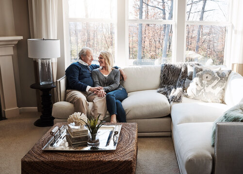 Smile, holding hands and senior couple at house with love, partner affection and bonding together. Happy, elderly people and embrace with admiration, retirement and relationship commitment in lounge