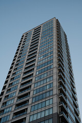 Fototapeta premium Modern high-rise apartment tower from low angle under blue sky
