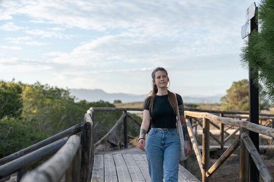 Young woman walking on boardwalk enjoying nature