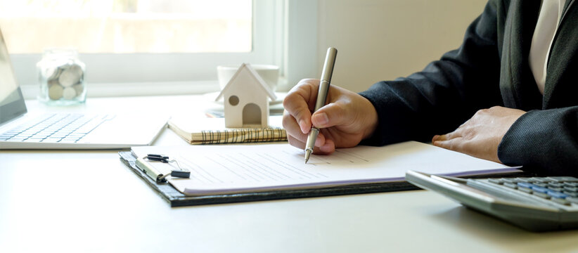 Business man signing documents Writing a signature on a contract or sales agreement.