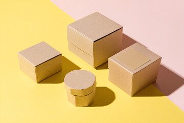 Fototapeta premium Four boxes and a container on a colorful background from a high angle